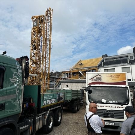 Fahrzeuge vor einem Dachstuhl