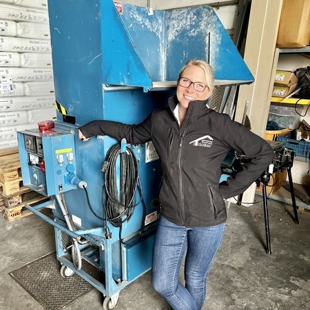 Facharbeiter vor einer Maschine für Einblasdämmung